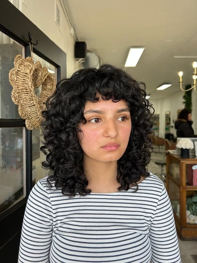 11. Rounded Curly Bob with Soft Black Color - Wispy Bangs For Curly Hair