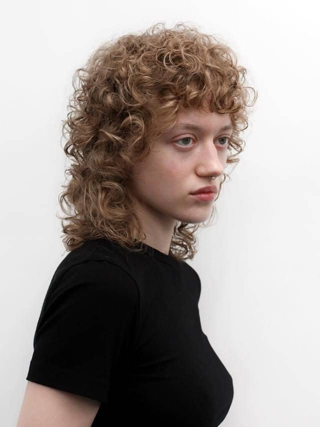15. Layered Curly Wolf Cut with Sandy Blonde Tone - Wispy Bangs For Curly Hair