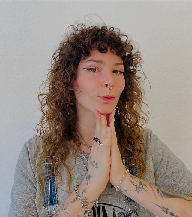 20. Curly Shag with Warm Caramel Brown Dimension - Wispy Bangs For Curly Hair