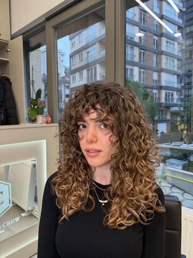 21. Defined Curly Layers with Honey Brown Balayage - Wispy Bangs For Curly Hair