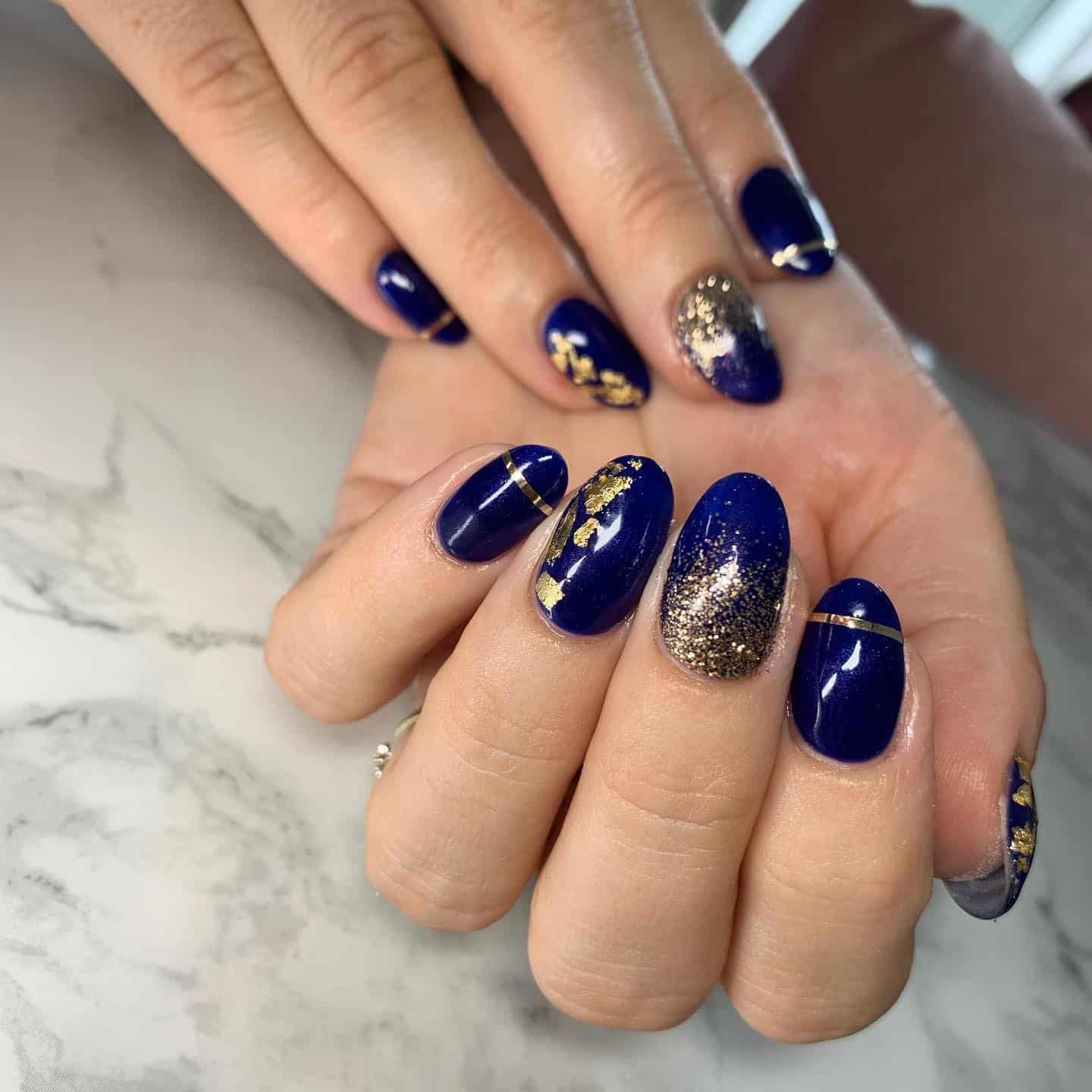3. Midnight Blue and Gold Foil Accent Nails - navy and gold nail ideas
