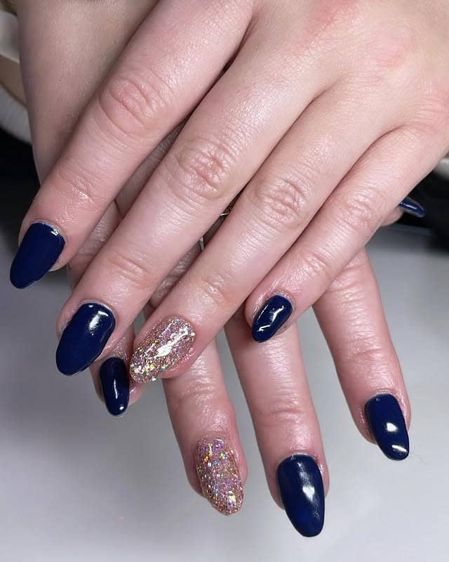 8. Navy Blue Glitter Accent Almond Nails - navy and gold nail ideas