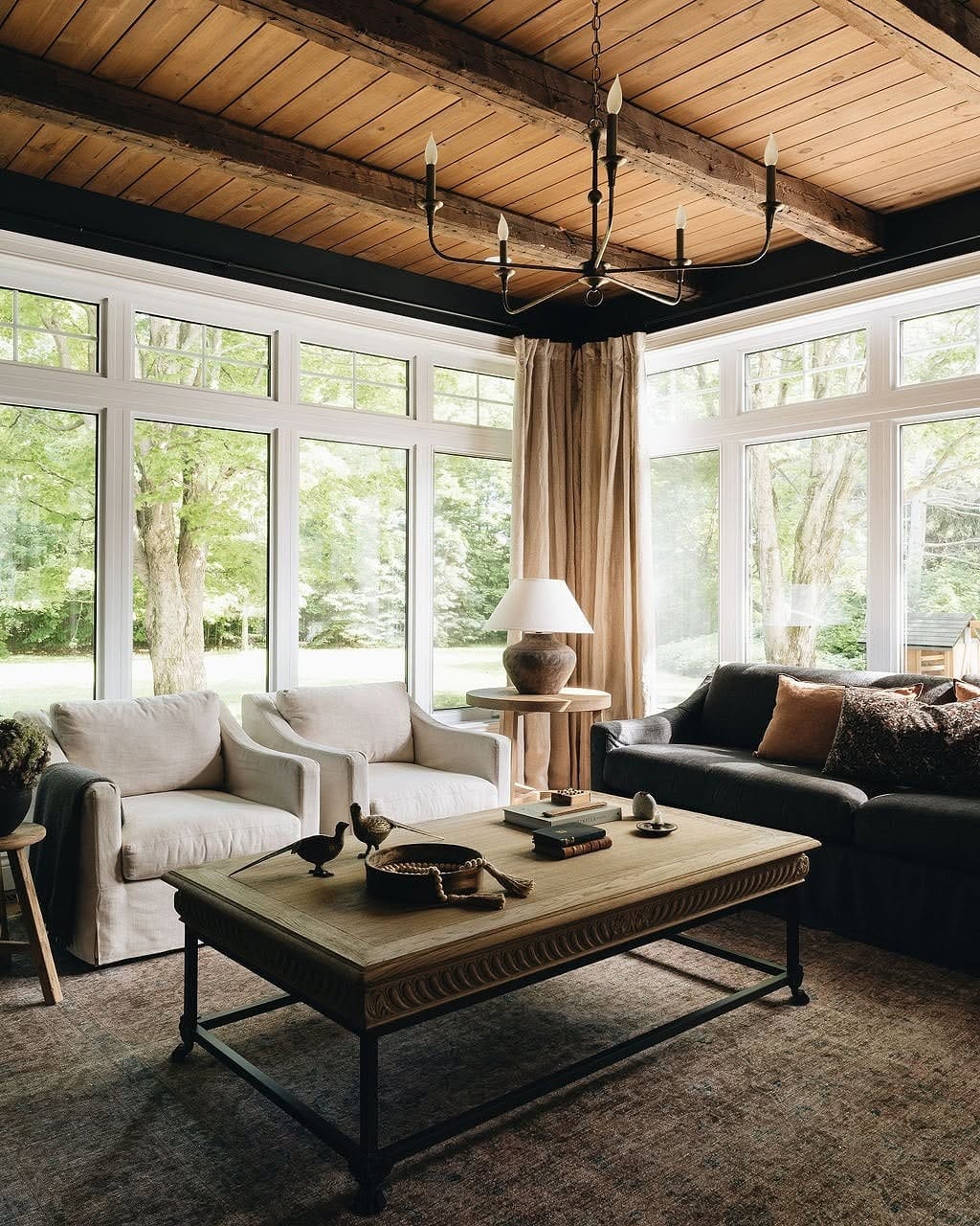 7. Moody Cottage Living Room with Wood Ceiling Beams - moody living room ideas