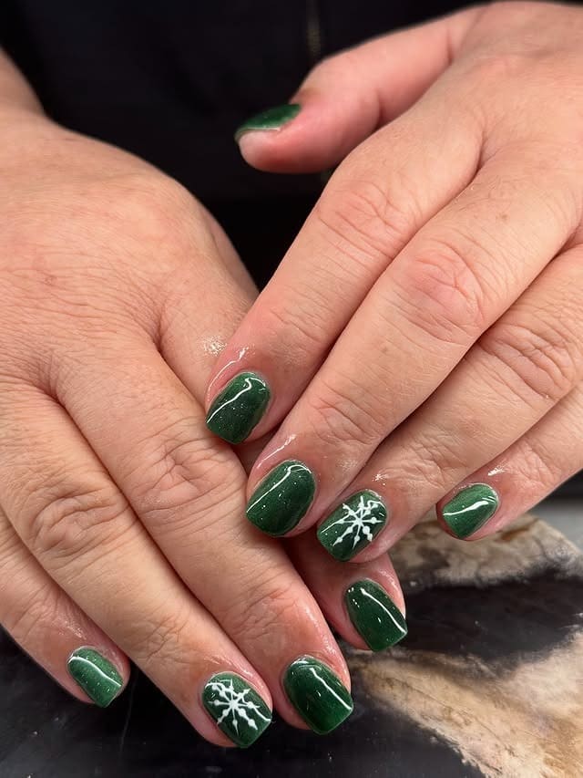 10. Dark Green Short Nails with Snowflake Accent - green nail ideas