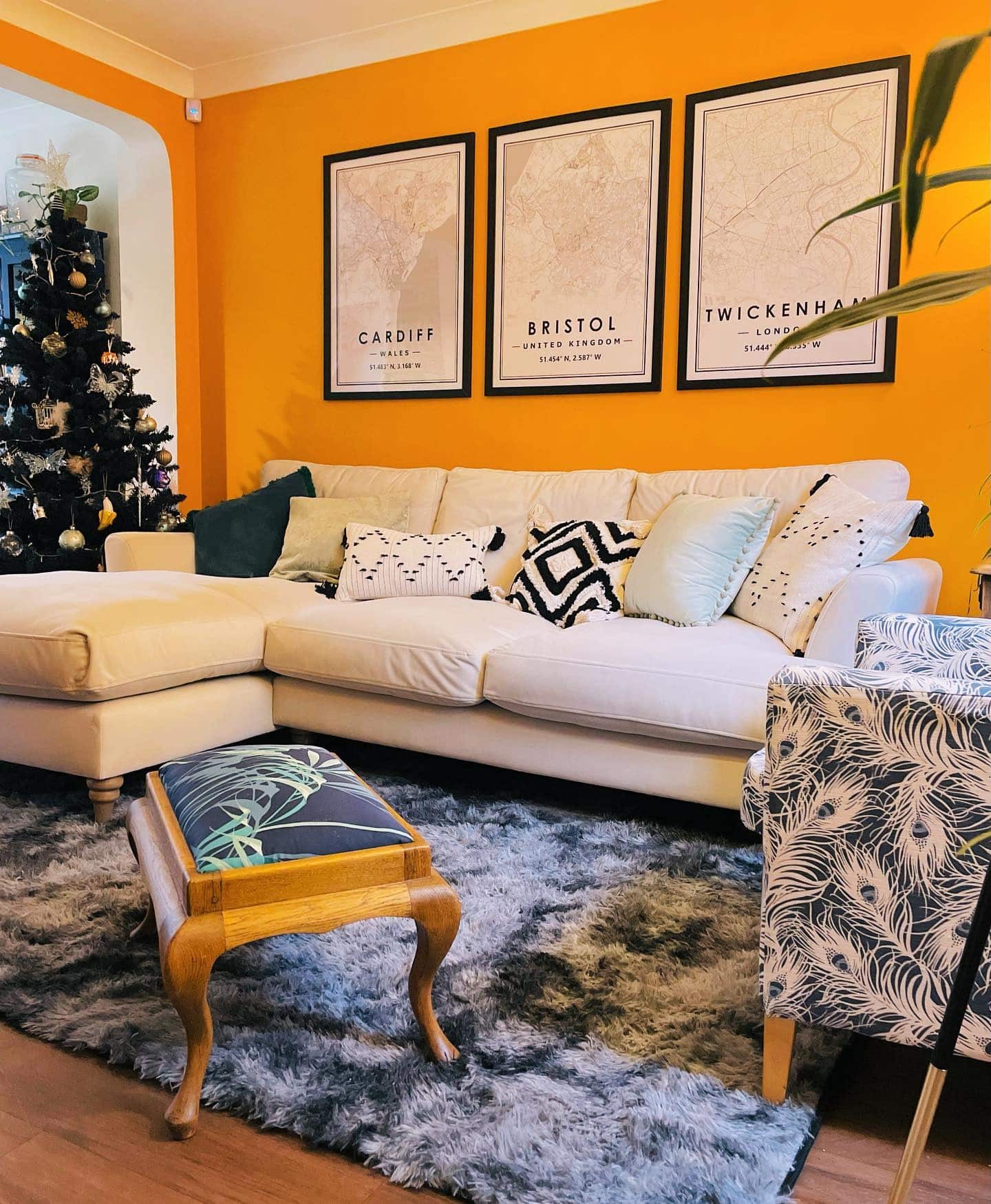 2. Golden Orange Accent Wall with Soft Neutral Seating - orange living room ideas