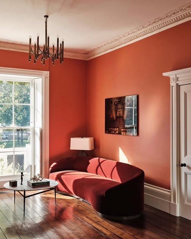 4. Terracotta Orange Living Room with Elegant Curved Sofa - orange living room ideas