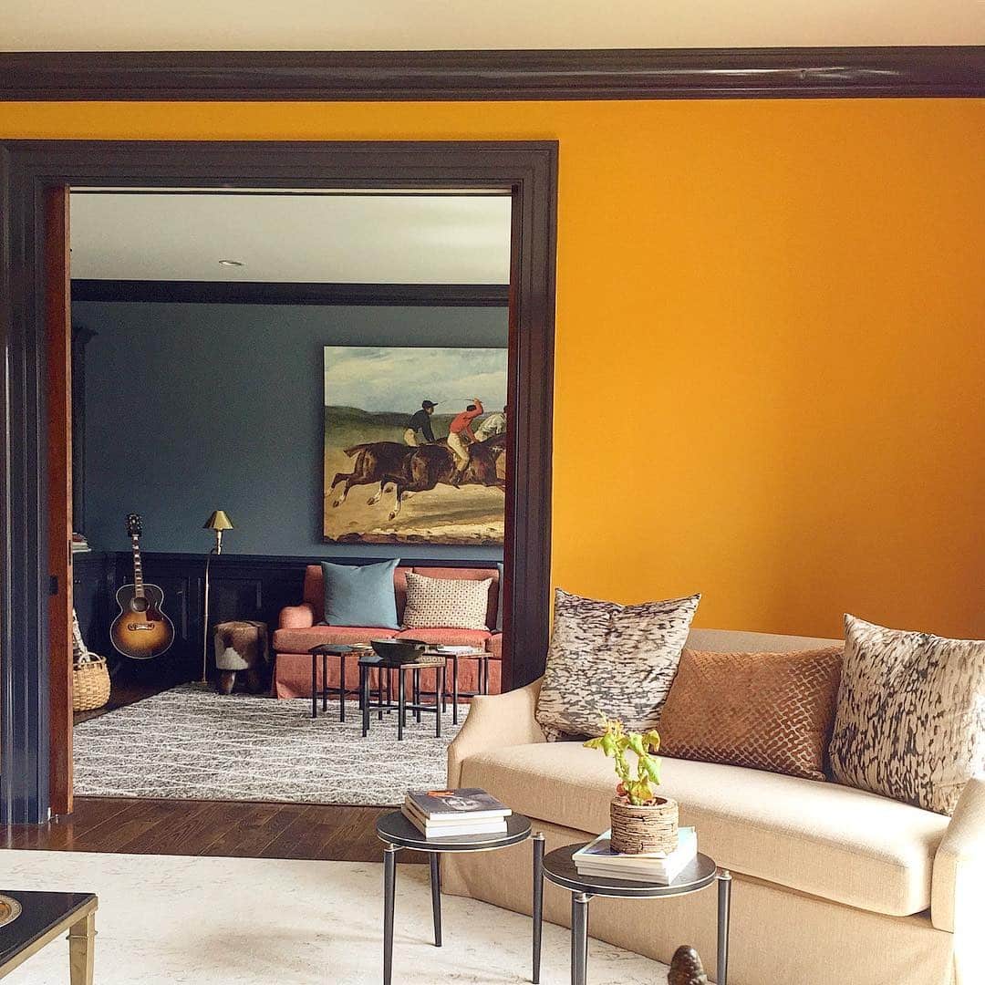 7. Mustard Orange Accent Wall with Moody Modern Contrast - orange living room ideas