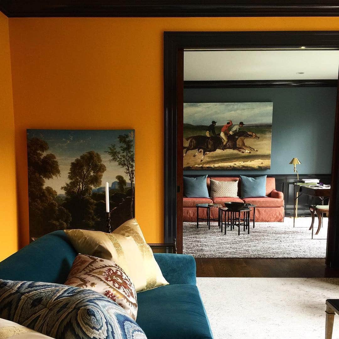 11. Moody Orange Living Room with Classic Art and Dark Trim - orange living room ideas