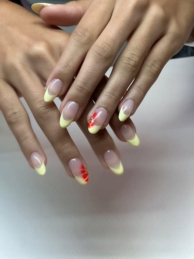 1. Soft Lemon French Tip Almond Nails with Floral Accent - yellow french tip nail ideas