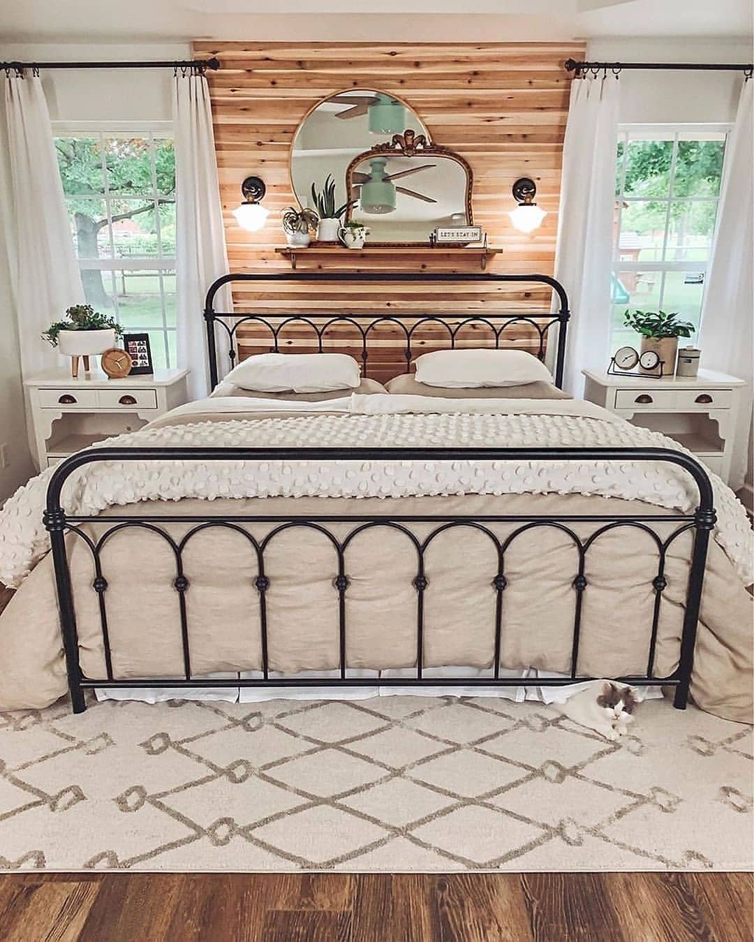 3. Rustic Iron Bed Farmhouse Bedroom with Wood Accent Wall - farmhouse bedroom ideas