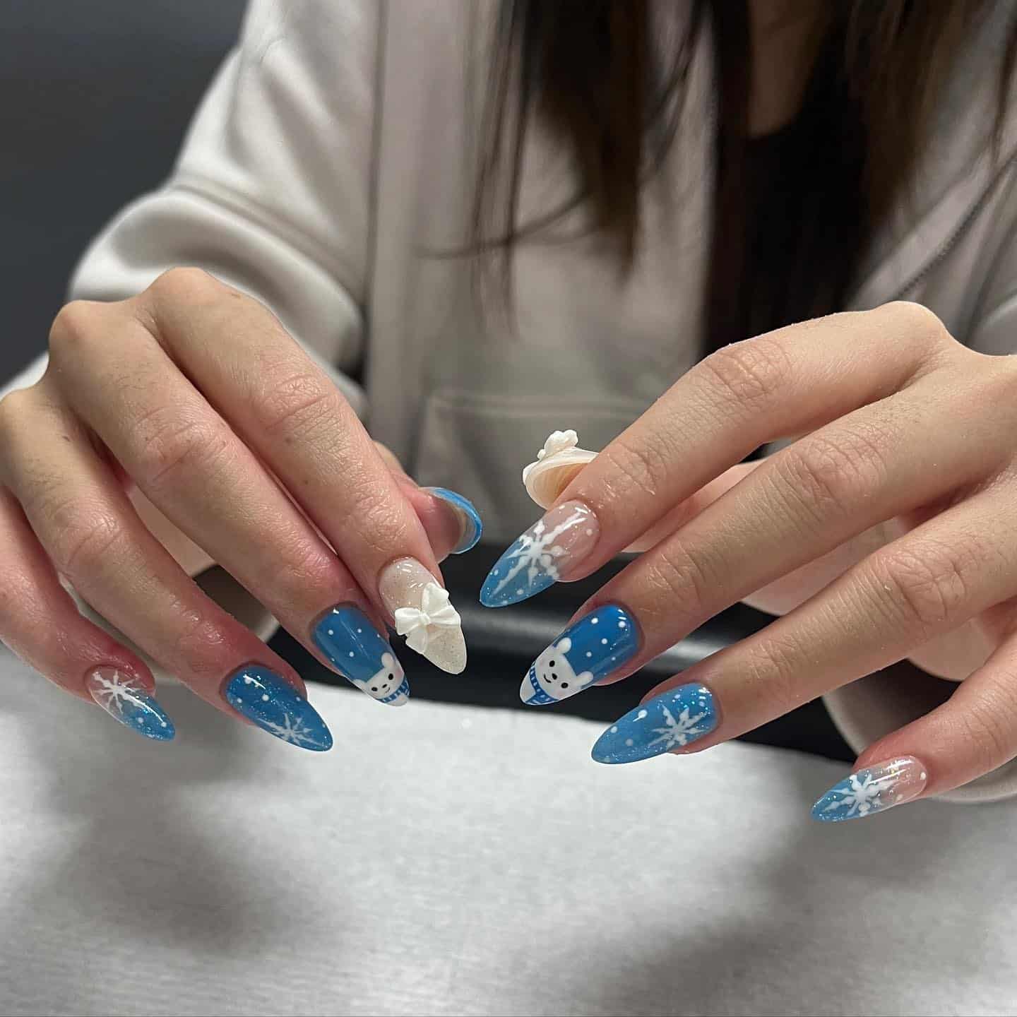 5. Frosted Blue Snowflake Almond Nails - winter almond nail ideas