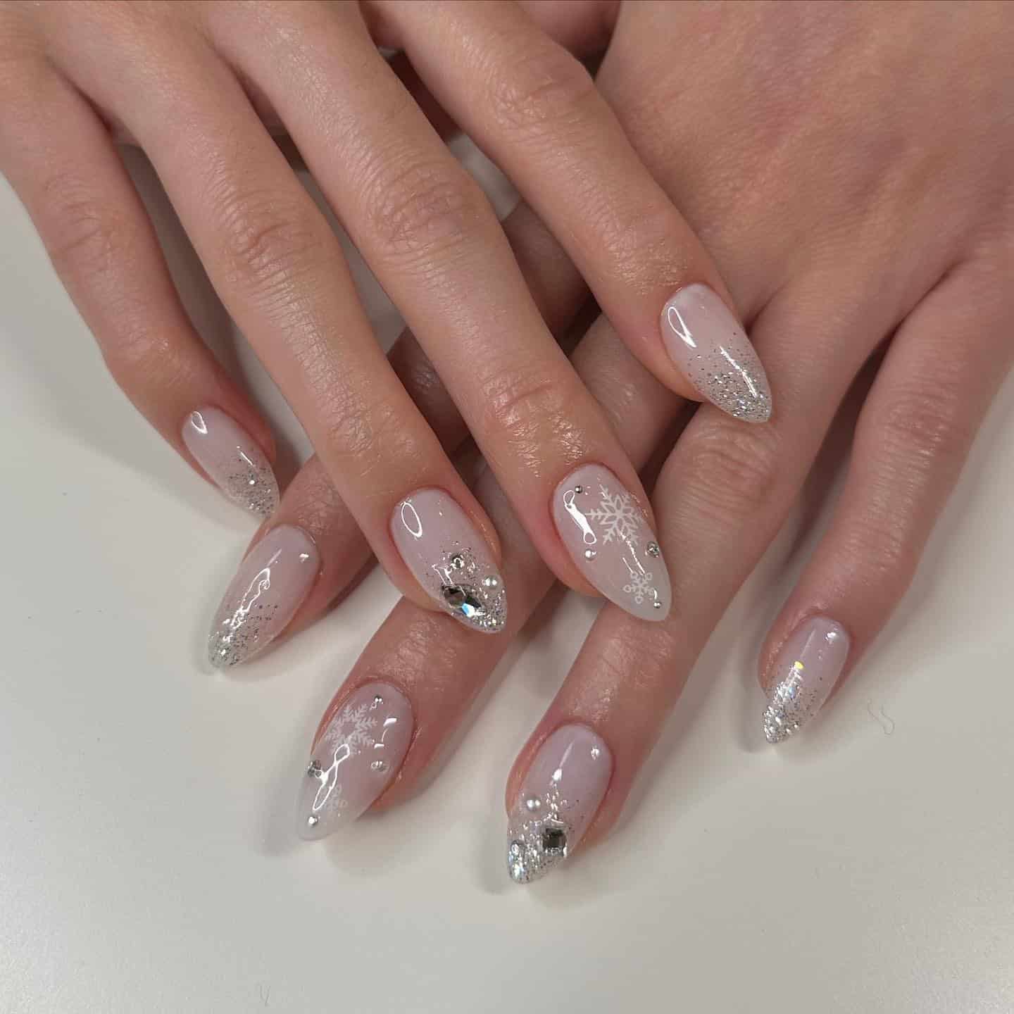 22. Silver Snowflake Glitter Almond Nails - winter almond nail ideas