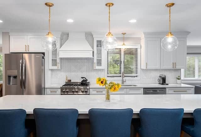 14. Bright White Kitchen With Gold Globe Pendants and Blue Seating - white and gold kitchen ideas