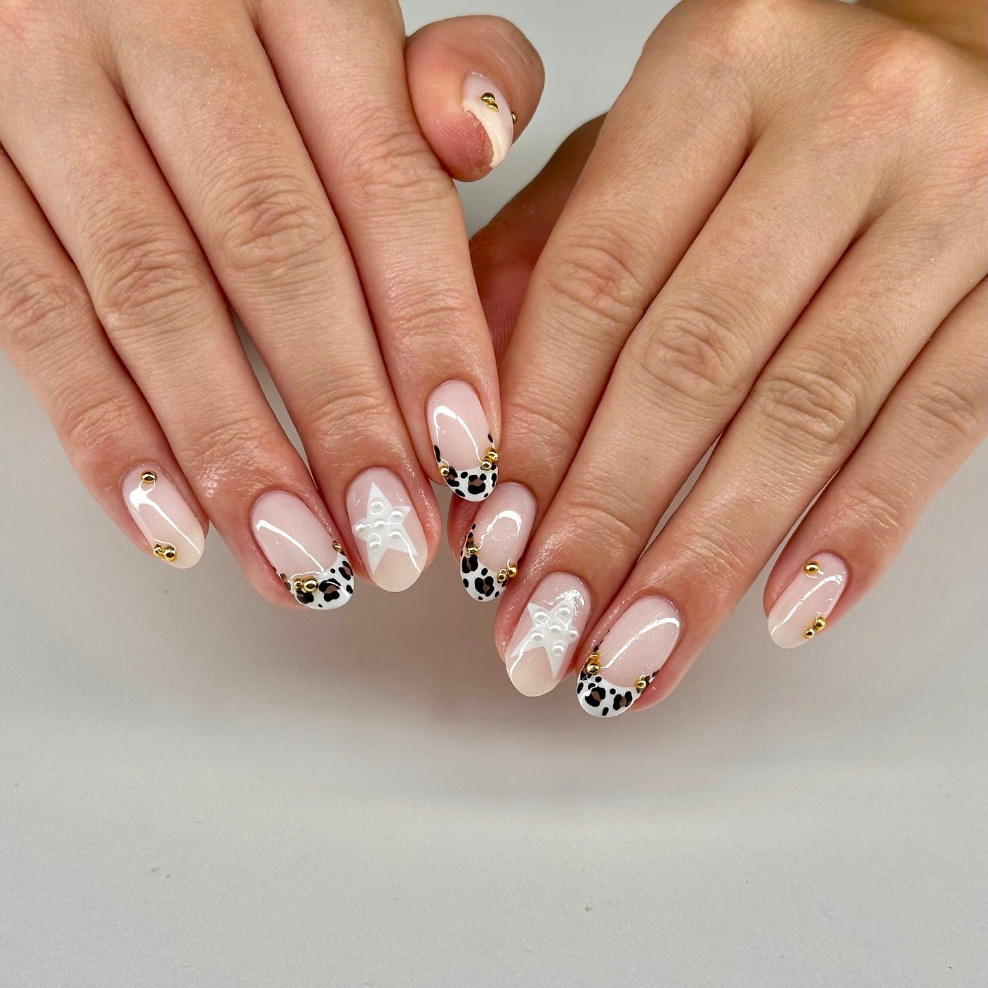 16. White Leopard Stud Accent Nails - cheetah nail ideas