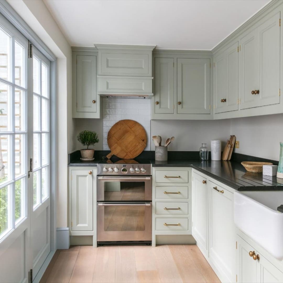 22. Sage Green Traditional Kitchen with Black Countertops - traditional kitchen ideas