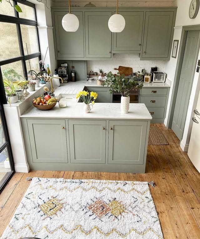 21. Cottage Sage Green Kitchen With Rustic Flooring - sage green kitchen ideas