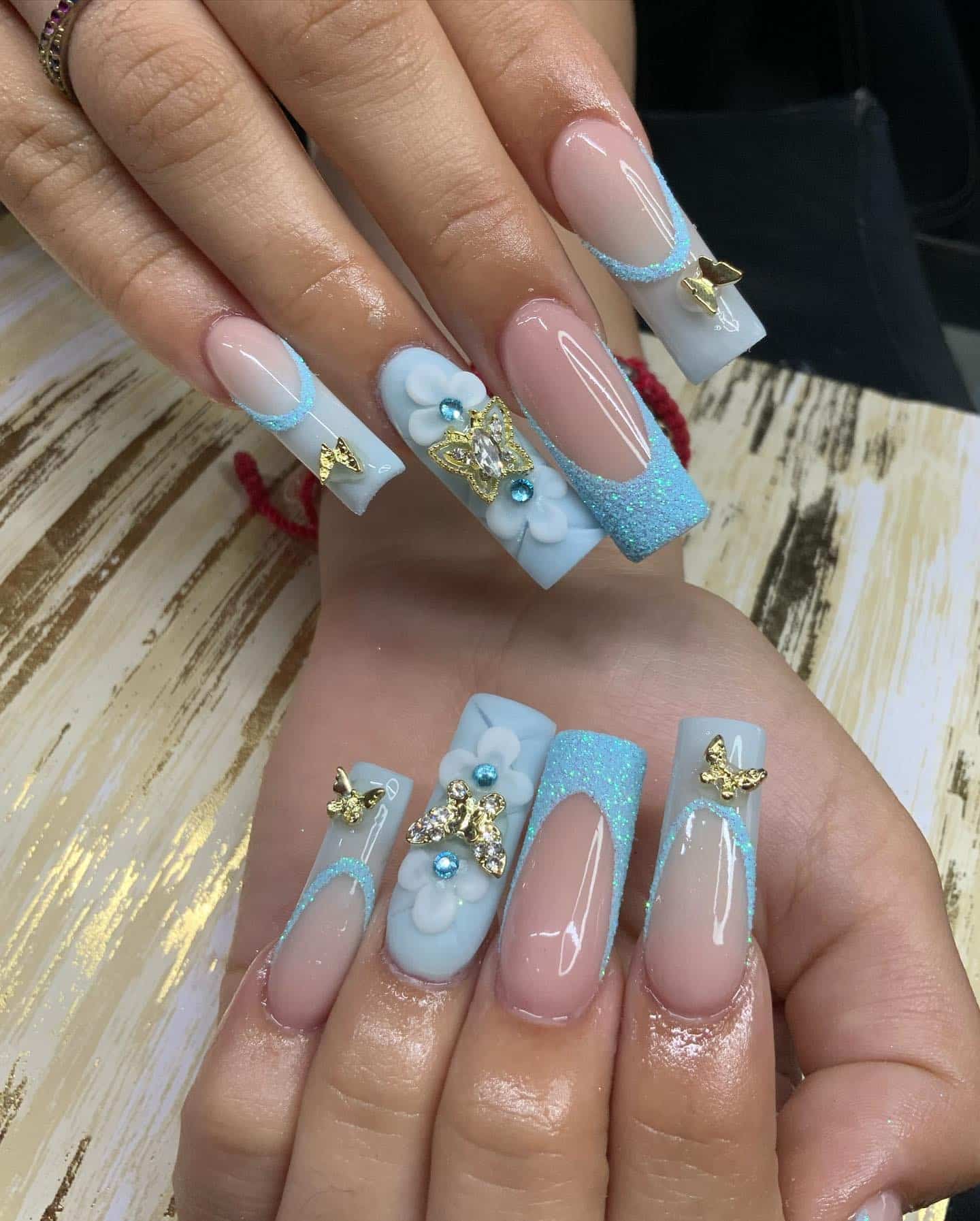 17. Baby Blue French Tip Coffin Nails with Gold Butterflies - easter nail ideas