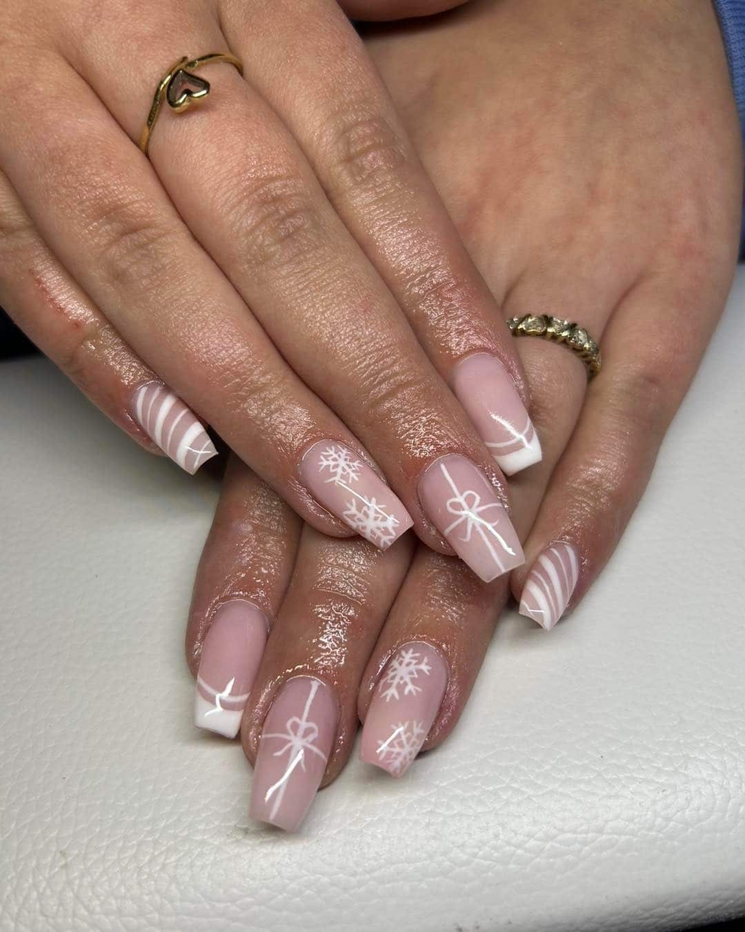 11. Nude Pink Gift Bow and Snowflake Winter Nails - white winter nail ideas