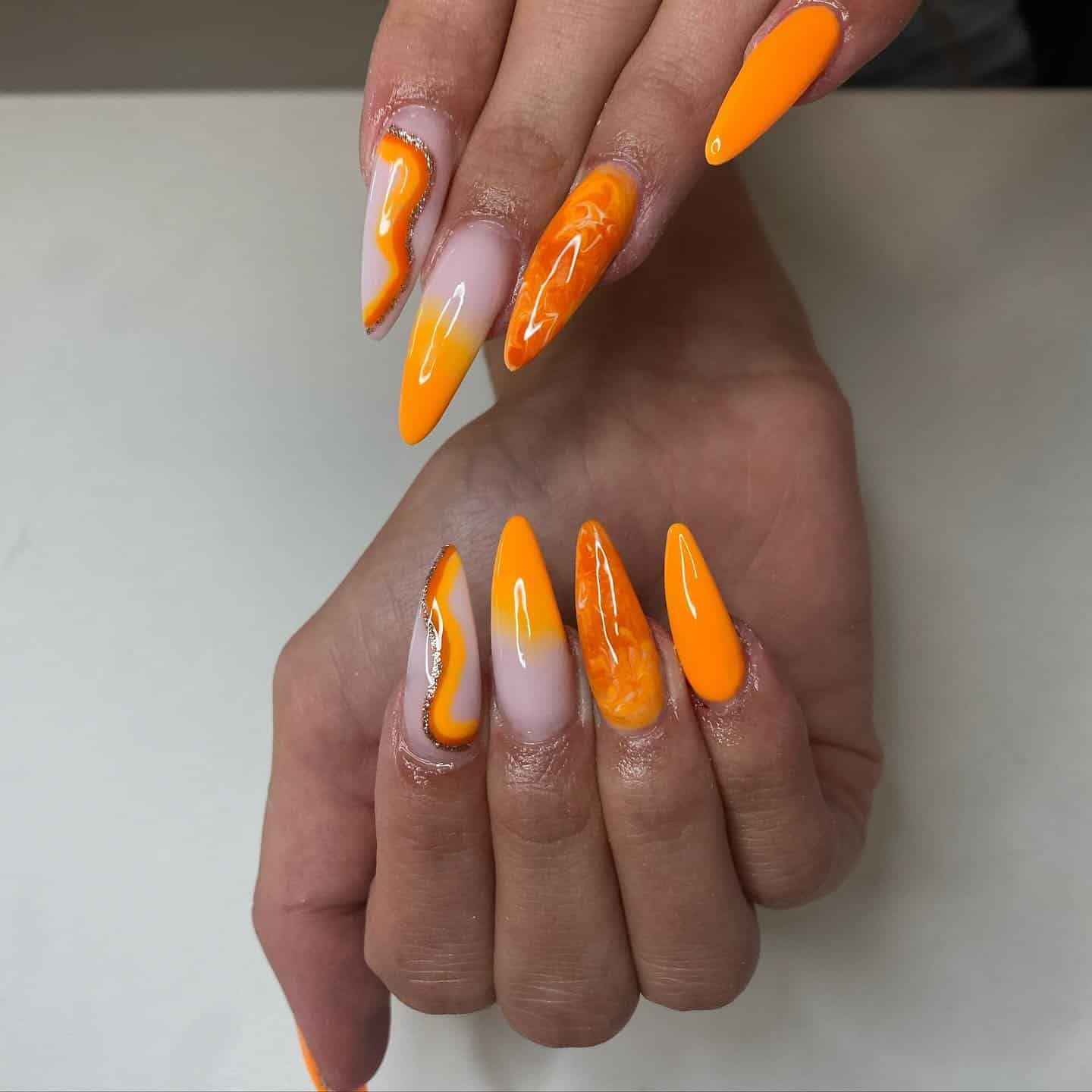 8. Sunset Orange Marble Stiletto Nails - orange color nail ideas