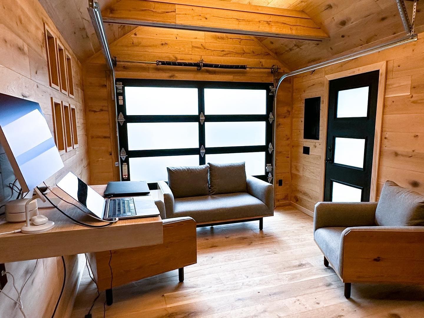 21. Warm Wood and Black Modern Cabin Garage Office - garage office ideas