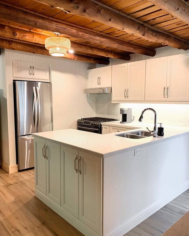 9. White Cottage Kitchen with Exposed Log Beams - cottage kitchen ideas