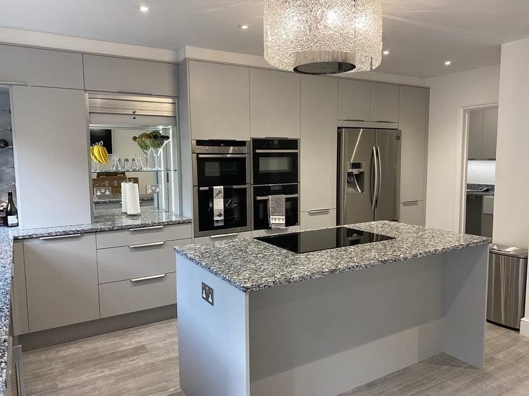 4. Soft Grey Handleless Kitchen With Statement Granite Island - light grey kitchen ideas