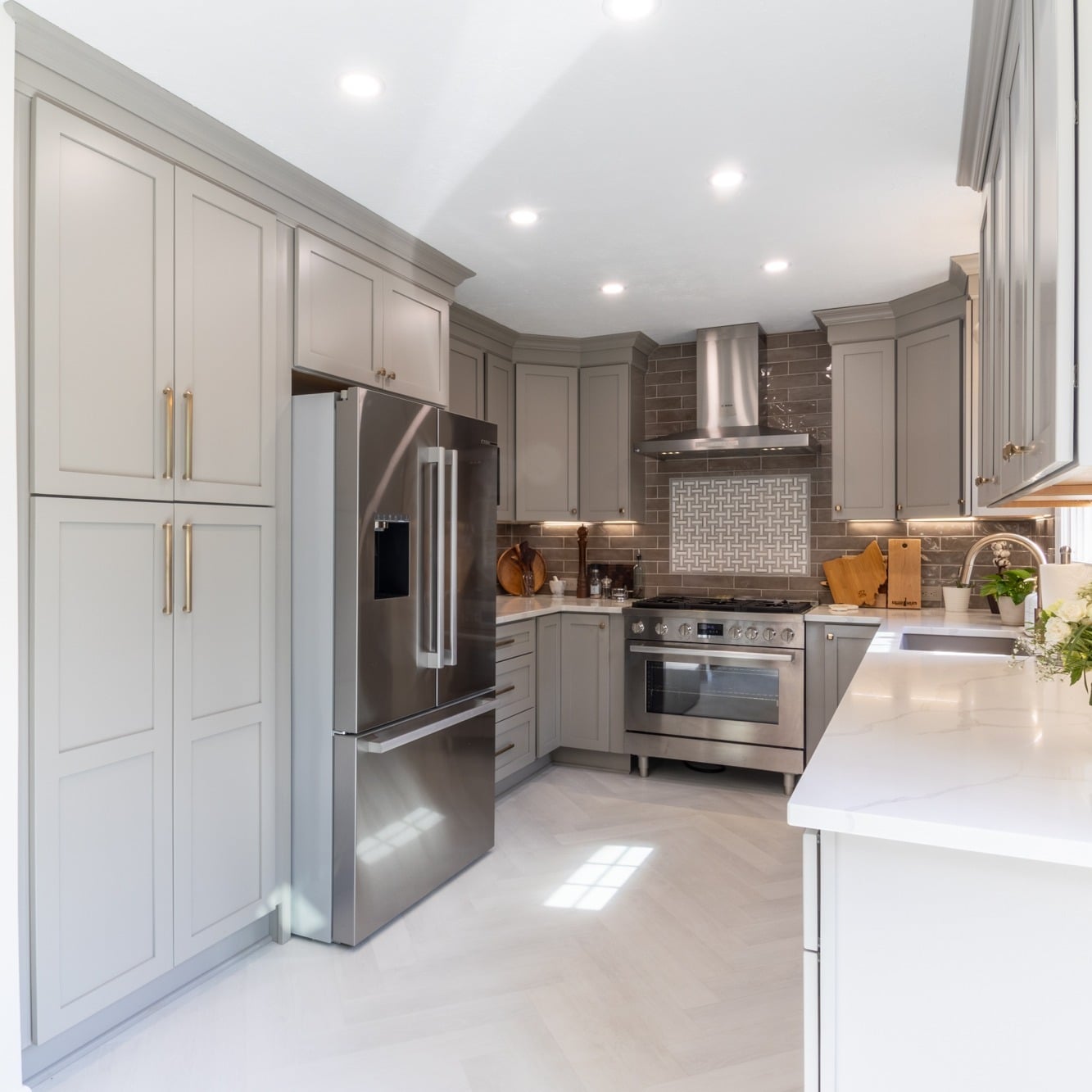 8. Two-Tone Grey Kitchen With Warm Metallic Hardware - light grey kitchen ideas