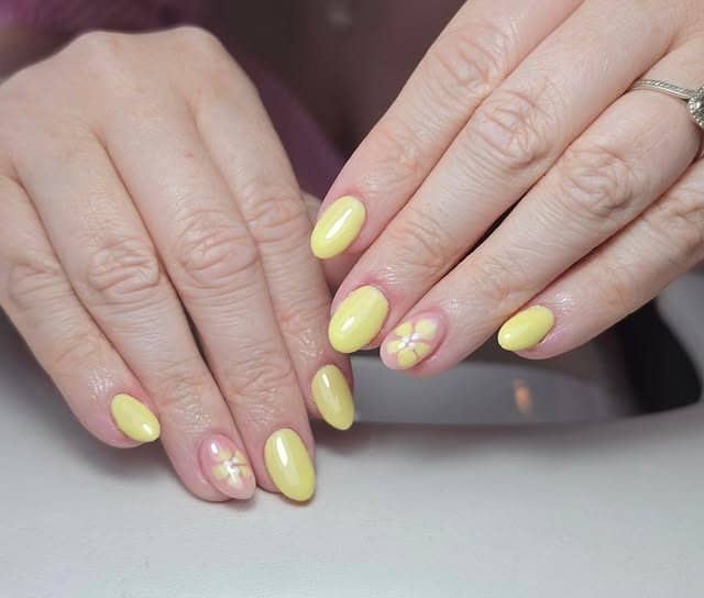 3. Solid Lemon Yellow Daisy Accent Nails - yellow nail ideas