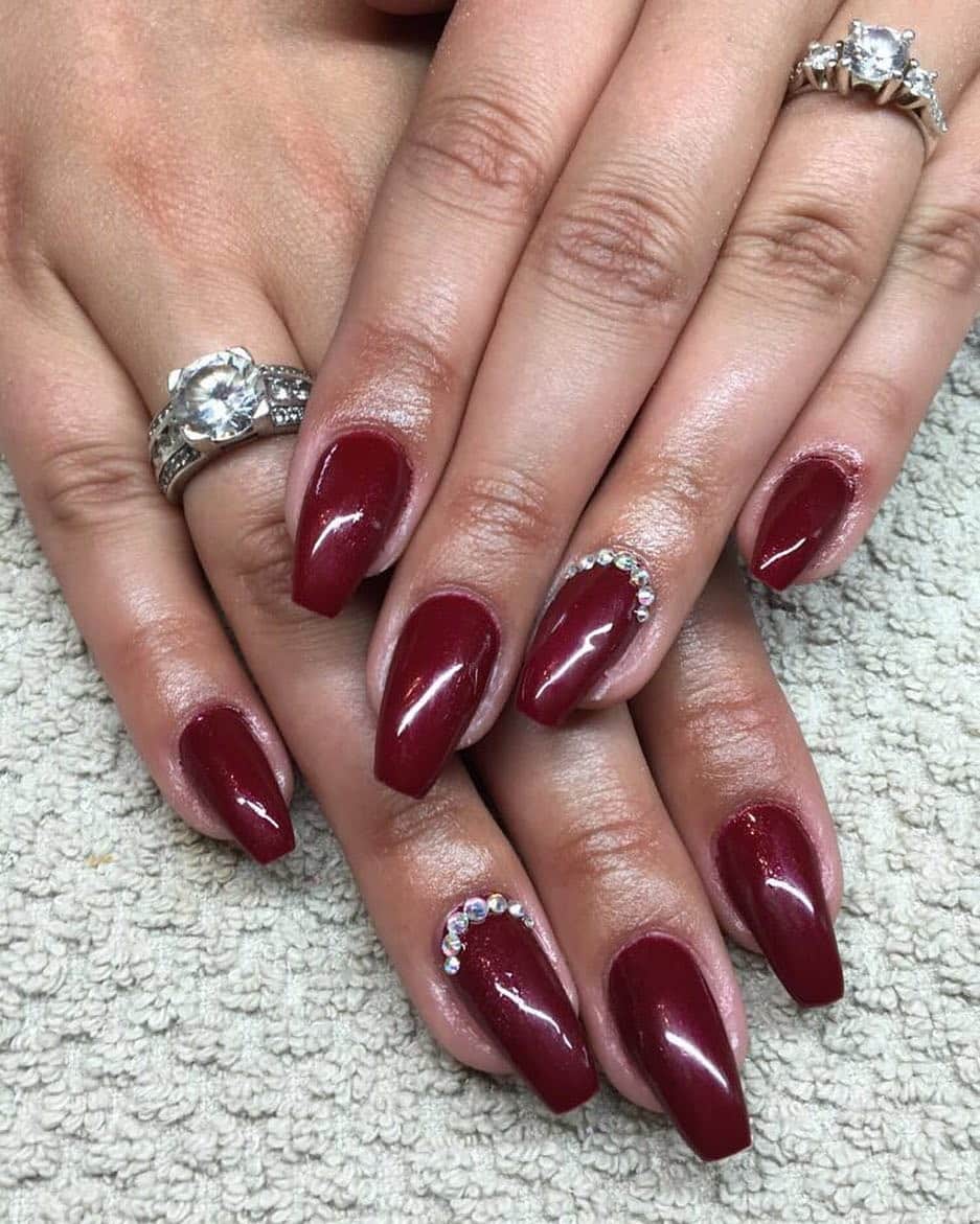 7. Dark Ruby Almond Nails with Crystal Accents - dark red coffin nail ideas