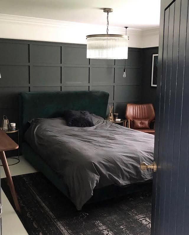 9. Black Paneled Bedroom with Leather Accent Chair - dark bedroom ideas