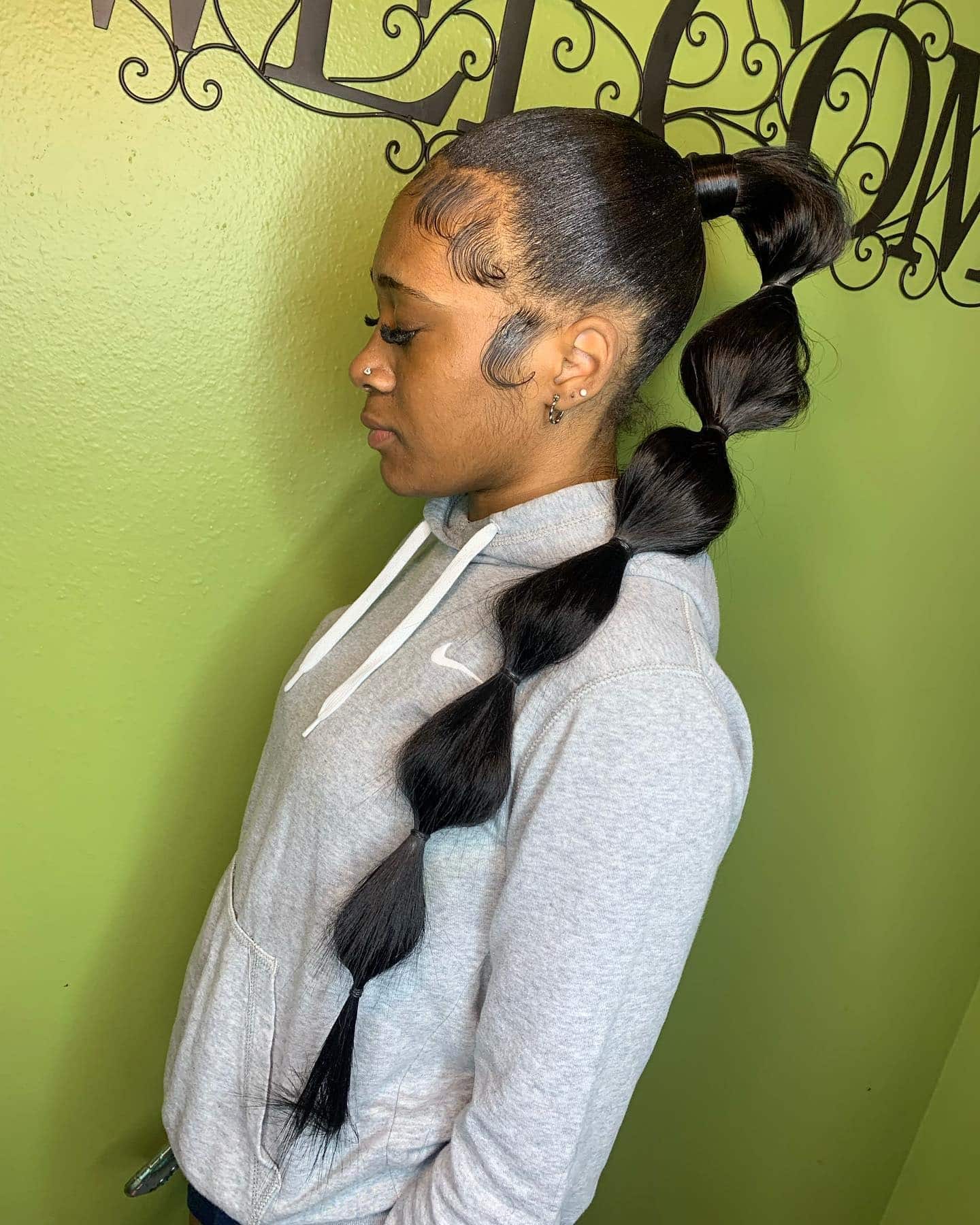 5. Midnight Black Bubble Ponytail with Sleek Edges - Space Buns Hairstyles