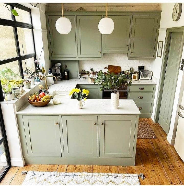 15. Sage Green Kitchen with Compact Island and Wood Floors - tiny kitchen ideas
