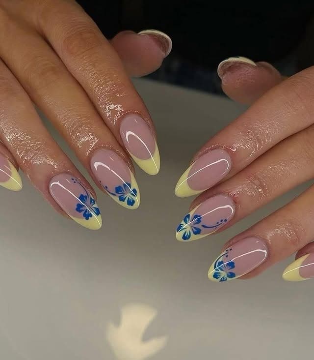 3. Pastel Yellow French Tip Nails with Blue Floral Art - floral nail ideas