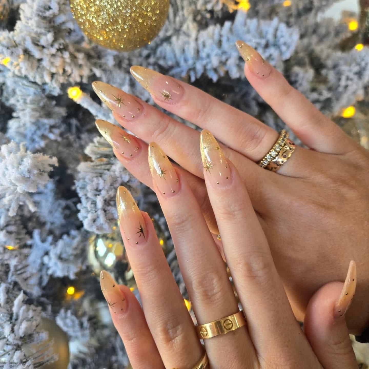 11. Gold Glitter Ombre Stiletto Nails with Star Accents - gold nail ideas