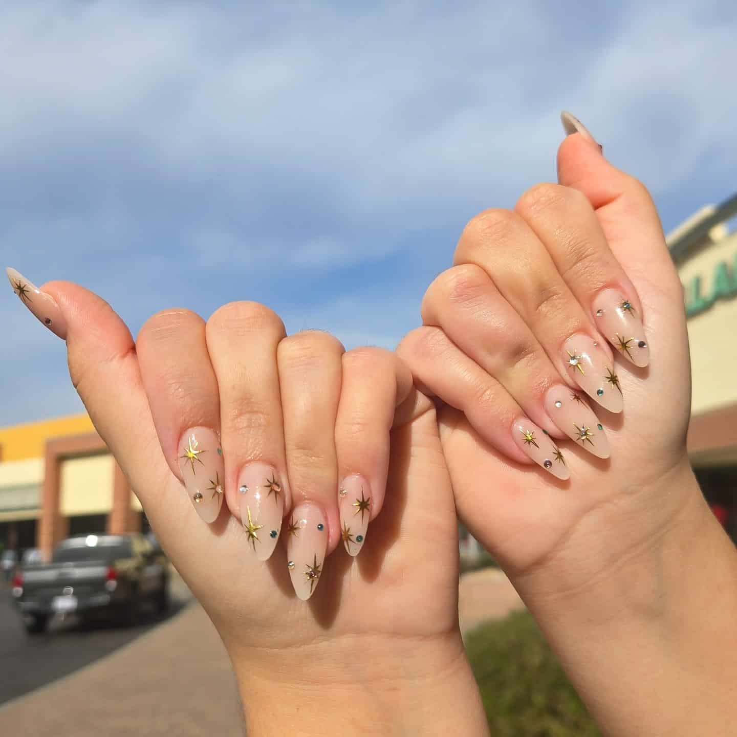 21. Celestial Nude Almond Nails with Gold Star Accents - gold nail ideas