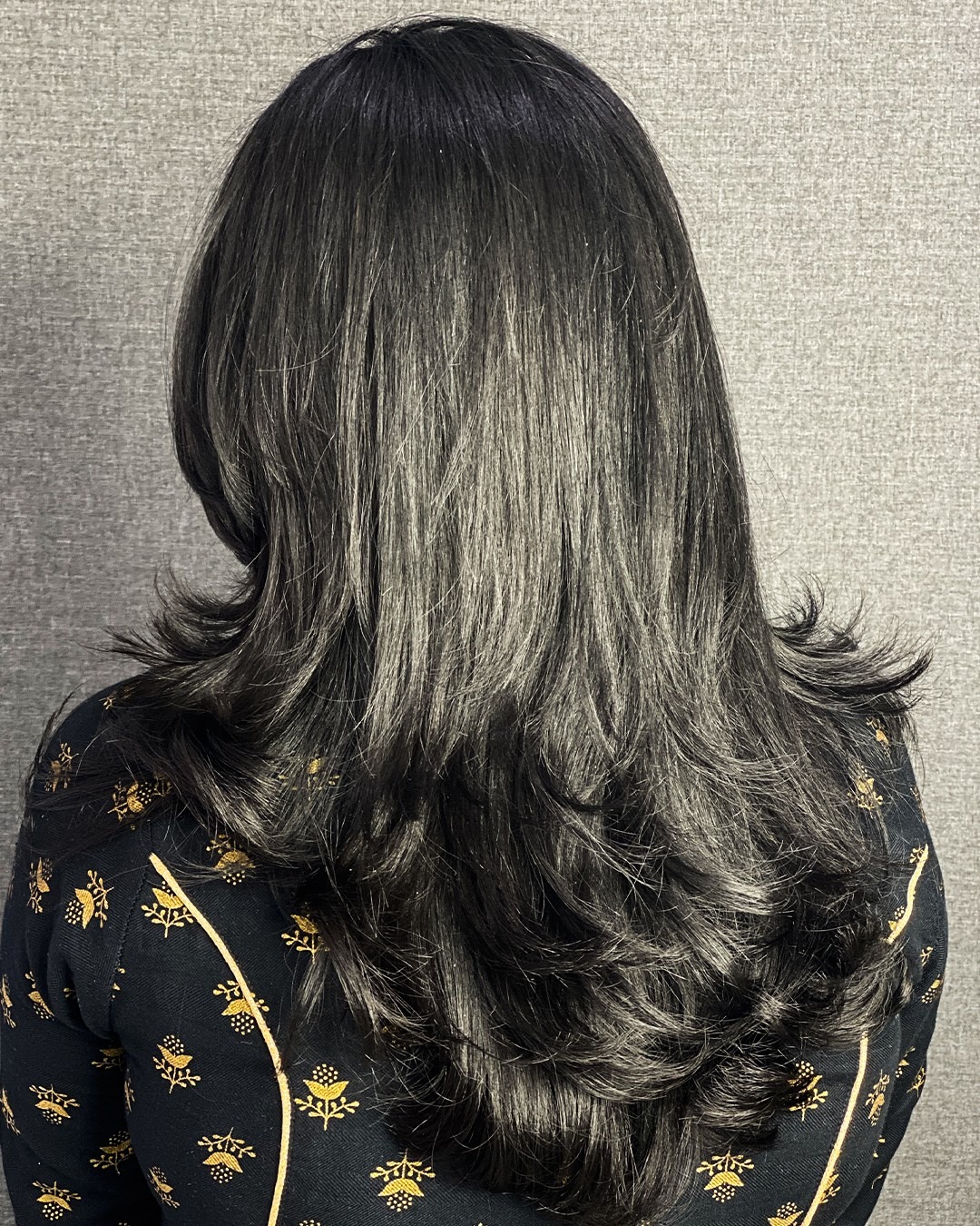 8. Layered Long Hair with Flicked Ends and Soft Black Color - Long Wispy Haircuts
