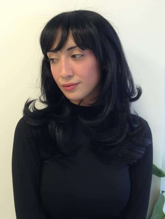 10. Curved Layered Blowout with Soft Black Wispy Bangs - Layered Hair With Wispy Bangs