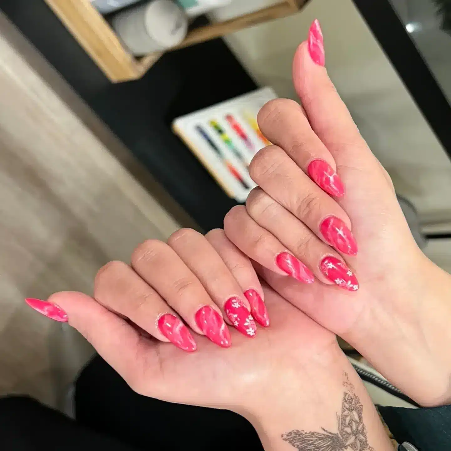 2. Hot Pink Marble Swirl Almond Nails with Floral Accents - hot pink nail ideas