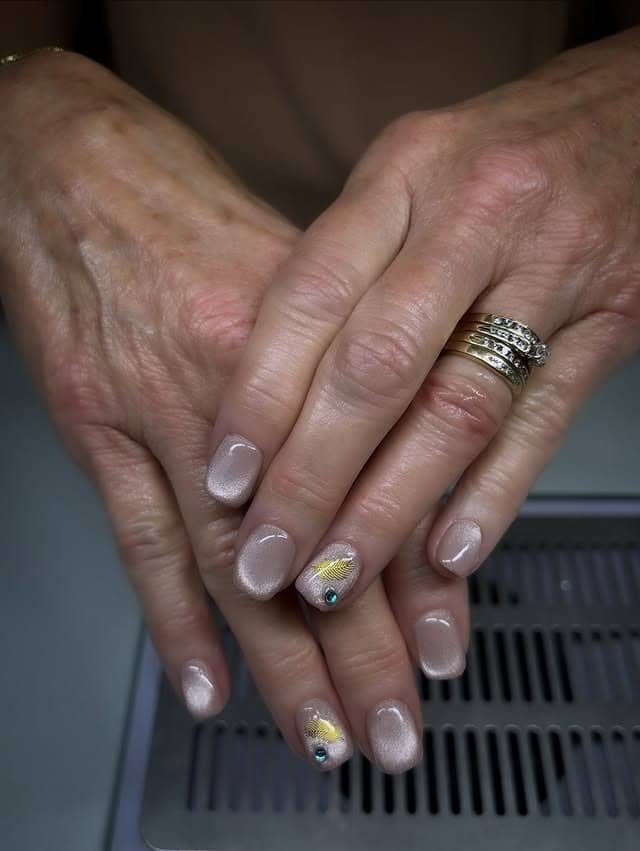7. Champagne Pearl Short Nails with Gold Feather Accents - holiday nail ideas