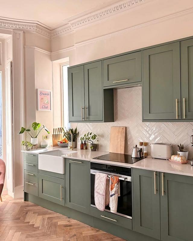 21. Soft Sage Green Kitchen With Herringbone Tile Backsplash - green kitchen ideas
