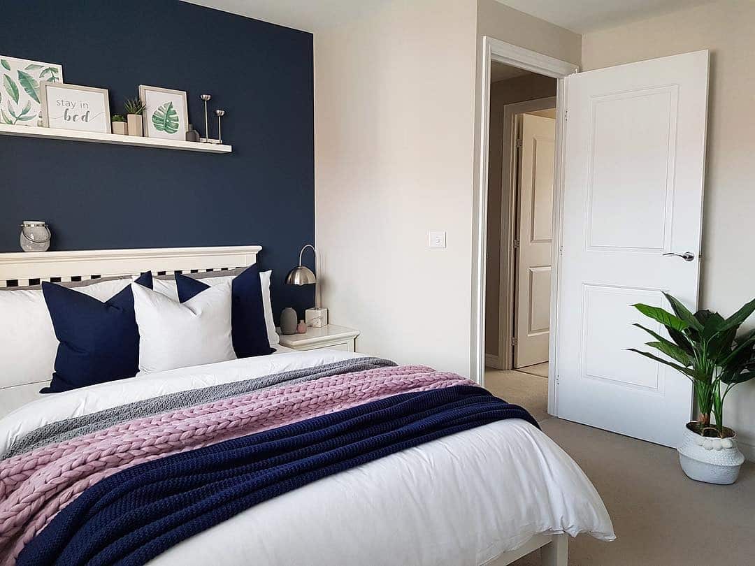 6. Navy Accent Wall with Soft Neutral Bedding - navy bedroom ideas