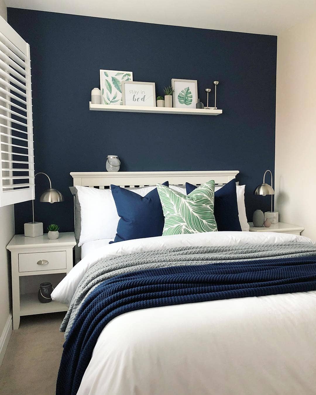 18. Navy Feature Wall with Botanical Decor - navy bedroom ideas