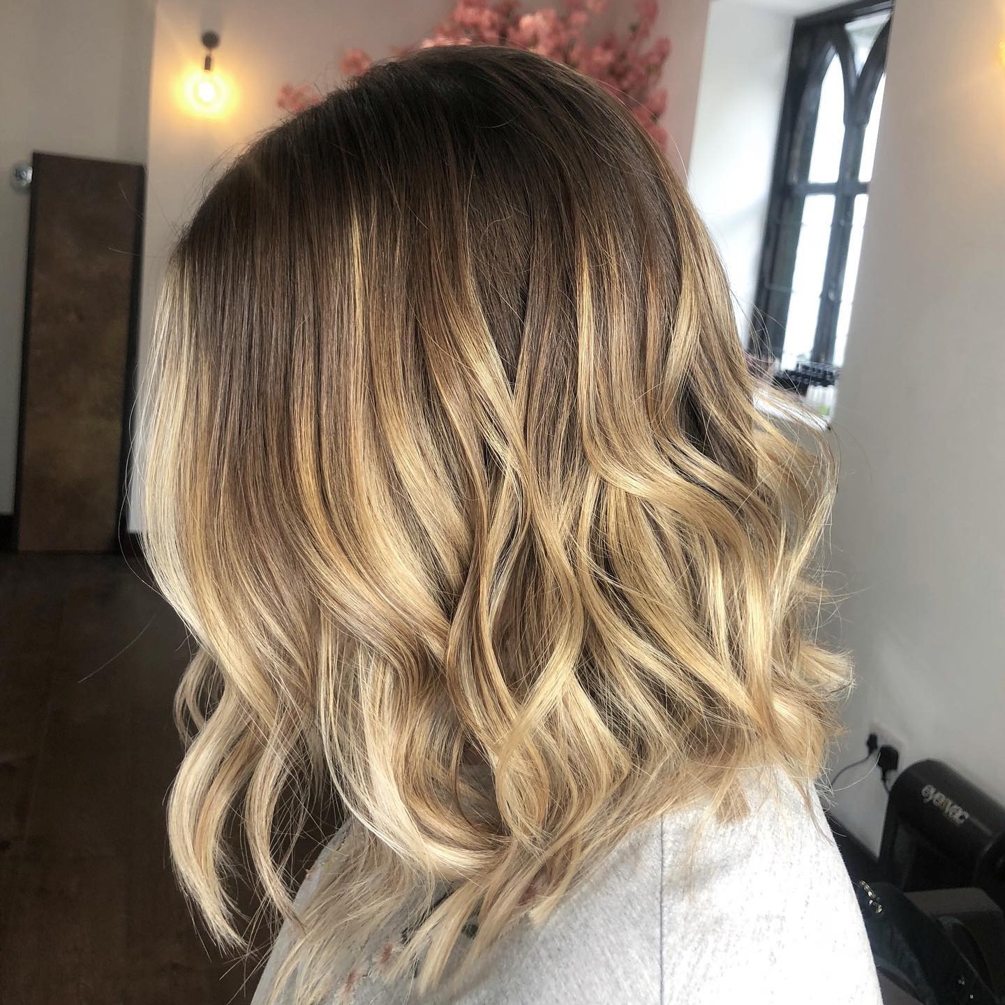 22. Rooted Champagne Blonde Wavy Midi Cut - Midi Cut Hairstyles