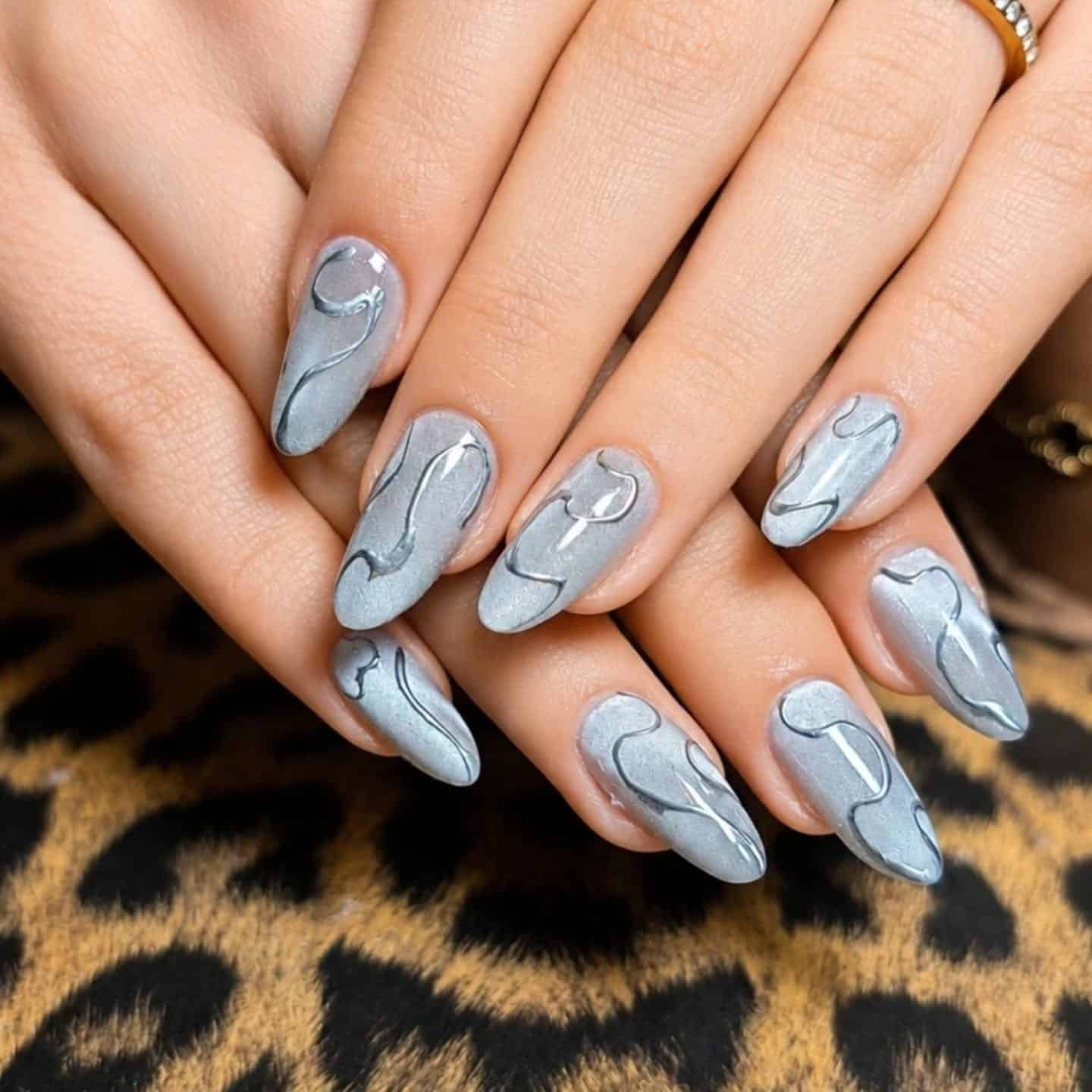 3. Pearl Gray Cat Eye Almond Nails with Metallic Swirls - silver nail ideas