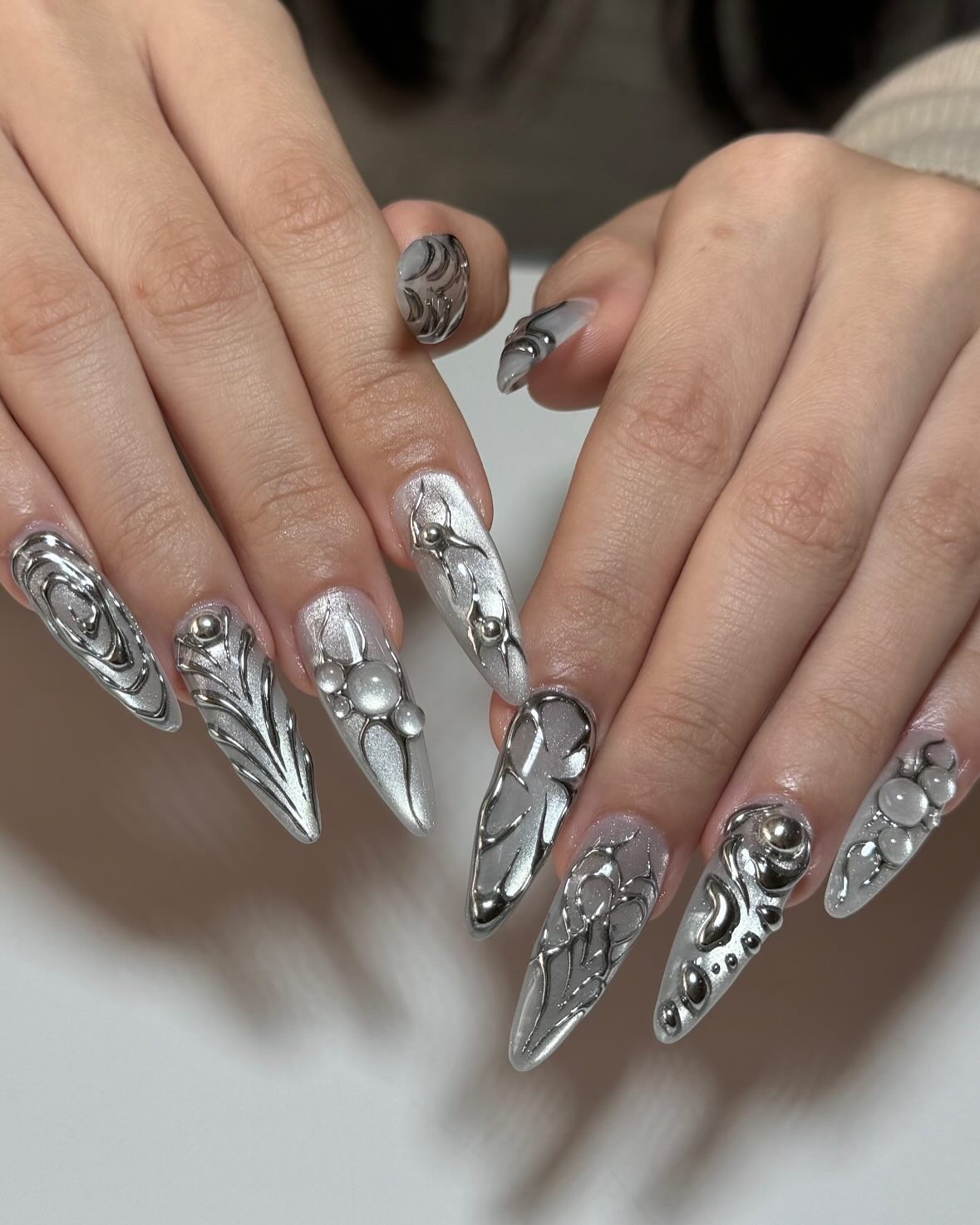 8. Silver Chrome 3D Stiletto Nails with Metallic Embellishments - silver nail ideas