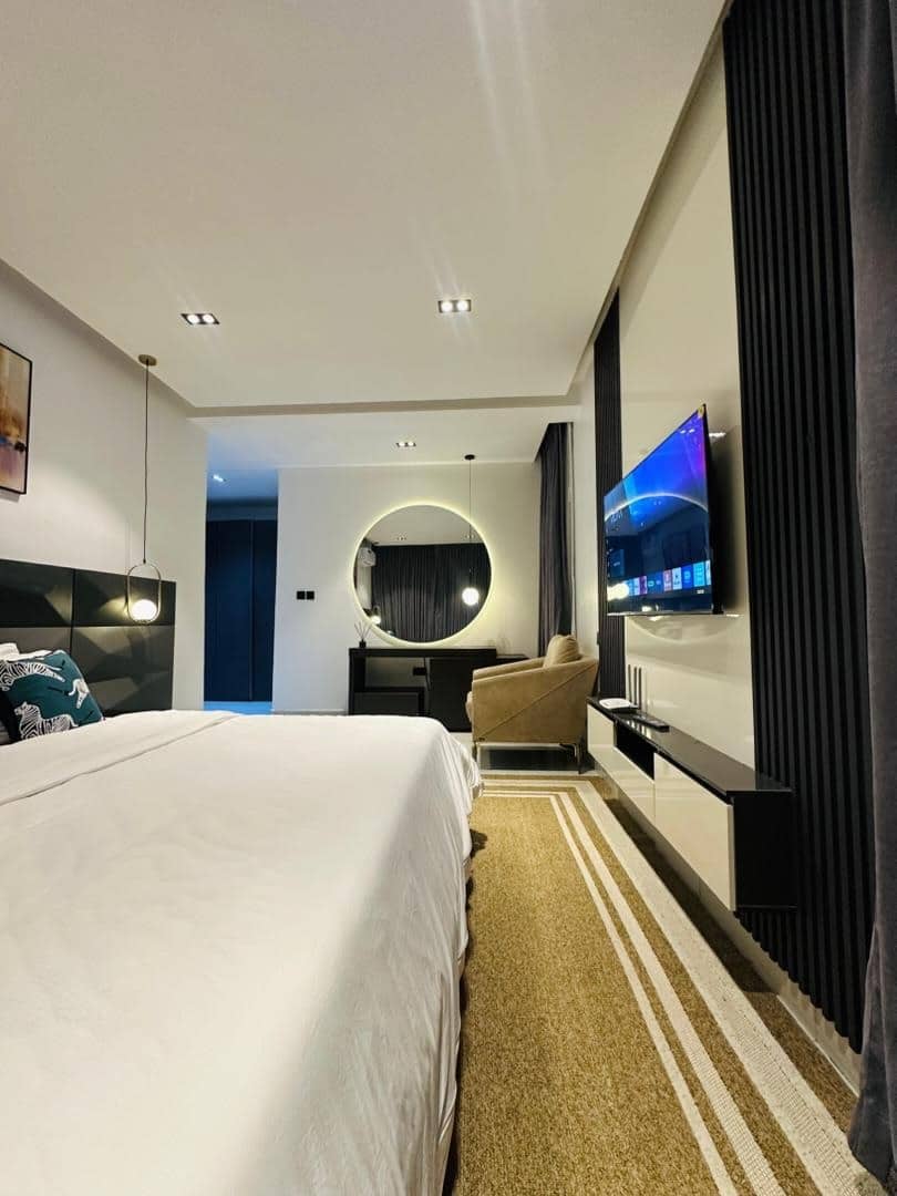 2. Black Fluted TV Feature Wall in a Neutral Bedroom - tv in bedroom ideas