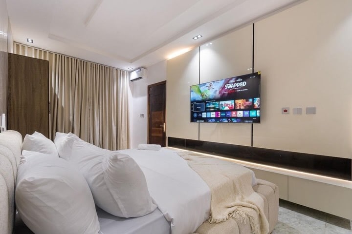 6. Minimalist Floating TV Console in White and Wood - tv in bedroom ideas