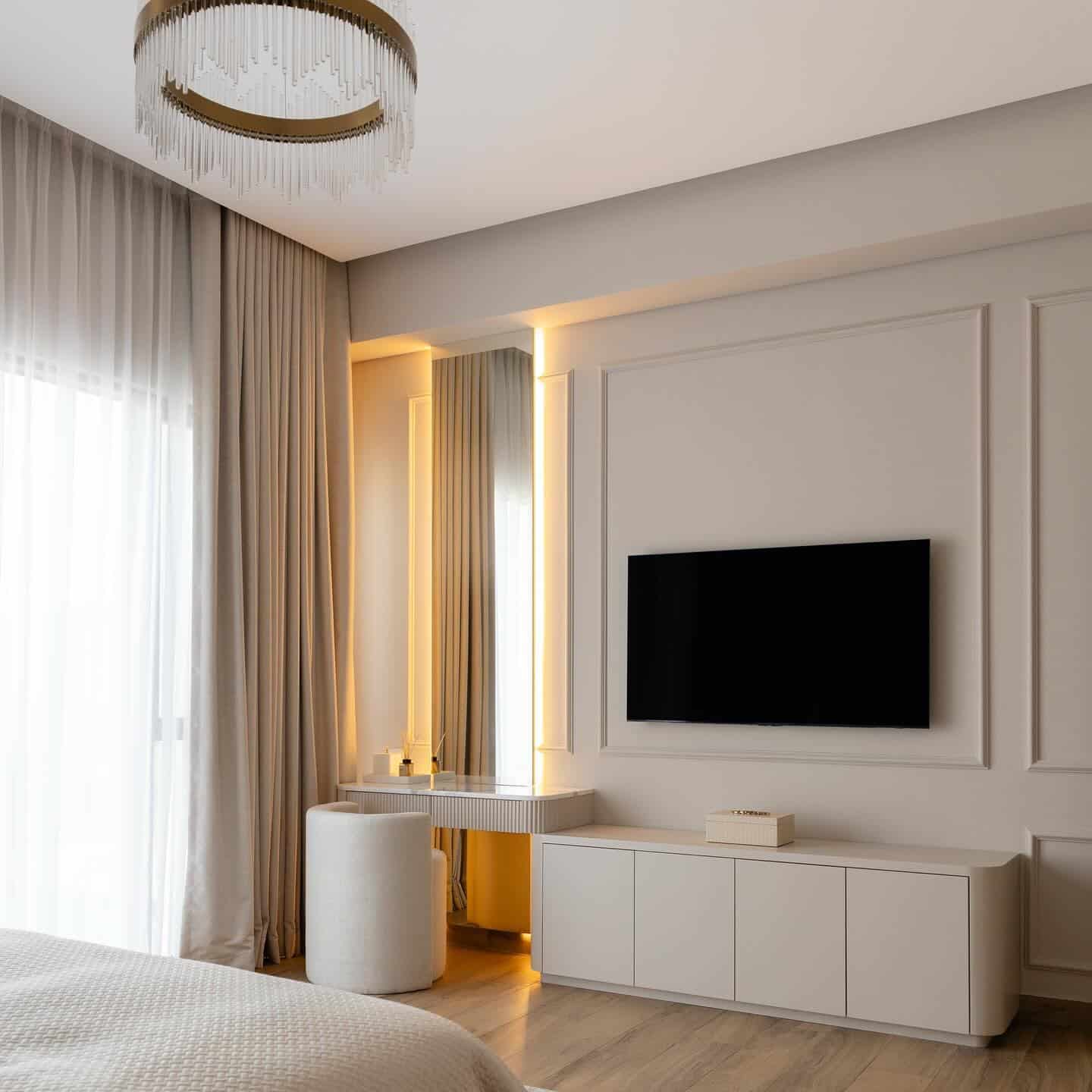 16. Elegant White TV Wall with Classic Panel Molding - tv in bedroom ideas