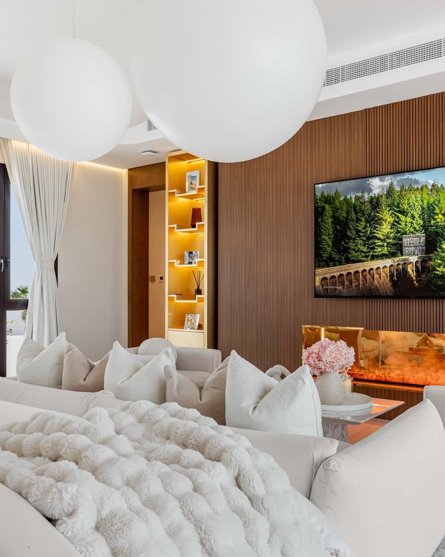 17. Walnut Slat TV Wall with Built-In Fireplace - tv in bedroom ideas