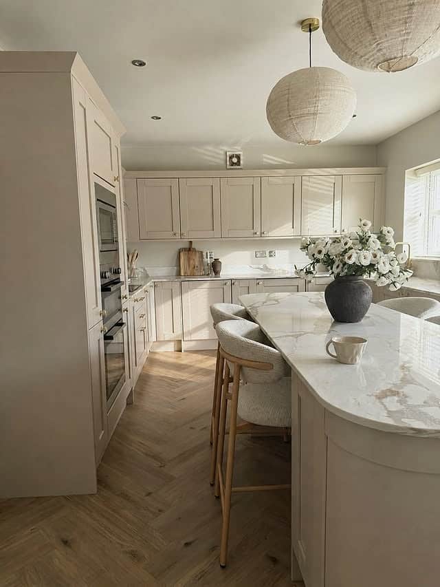 11. Warm Greige Shaker Kitchen with Marble Waterfall Island - light color kitchen ideas
